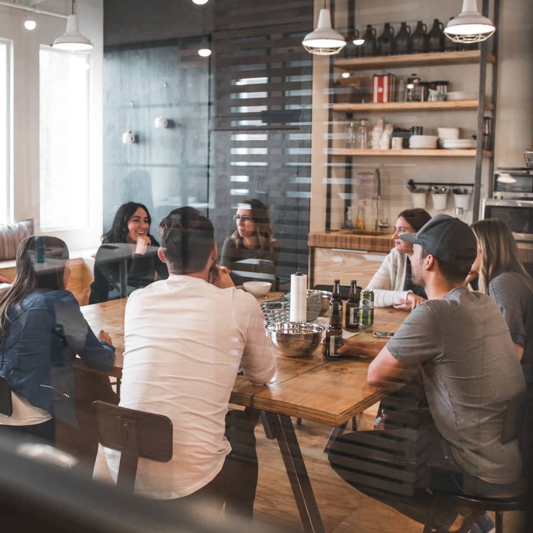 Group of people sat around a table having a discussion